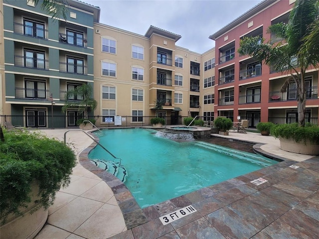 view of pool featuring a pool with connected hot tub and a patio