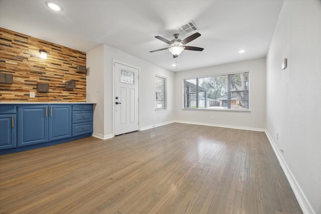 unfurnished living room featuring baseboards, visible vents, a ceiling fan, dark wood-style flooring, and recessed lighting