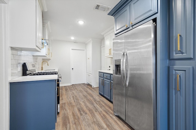 kitchen with visible vents, light countertops, appliances with stainless steel finishes, and blue cabinetry