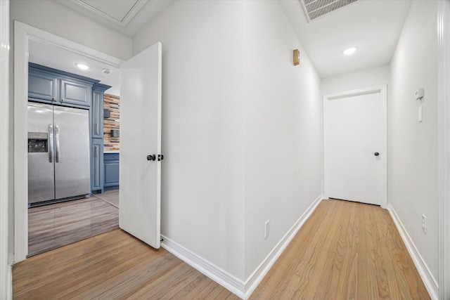 hallway with light wood finished floors, visible vents, baseboards, and recessed lighting