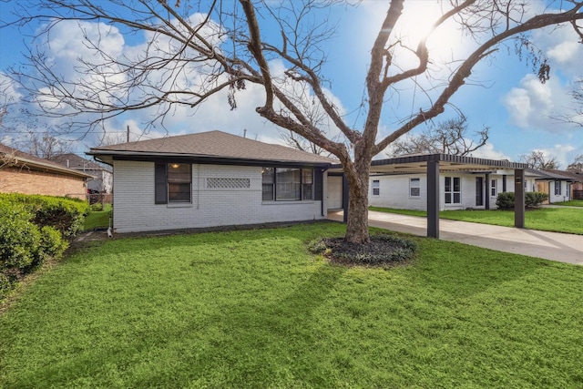 ranch-style home featuring roof with shingles, a front yard, driveway, and brick siding