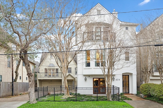 view of front of home featuring a fenced front yard, driveway, and stucco siding