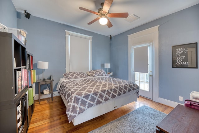 bedroom with a ceiling fan, light wood-type flooring, visible vents, and baseboards