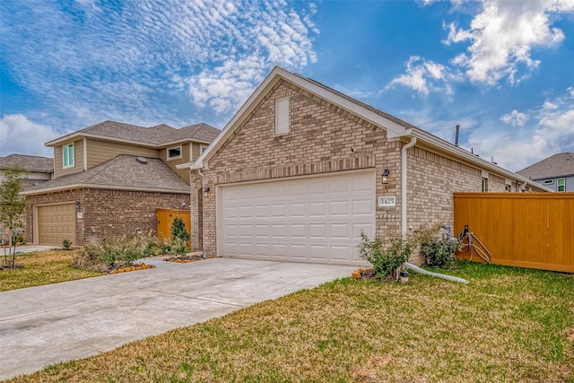 view of front of house featuring an attached garage, driveway, a front lawn, and brick siding