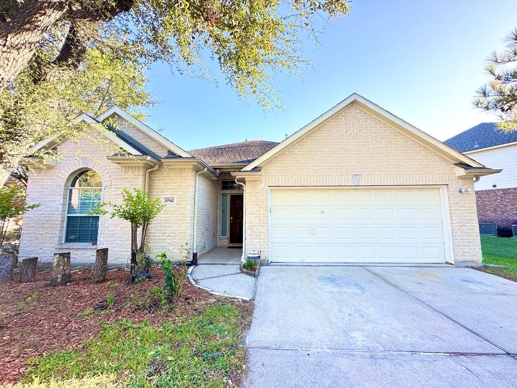 ranch-style house with a garage, concrete driveway, and brick siding