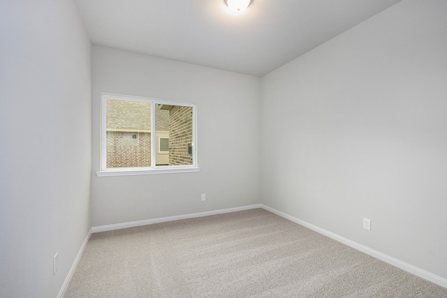 spare room featuring carpet floors and baseboards