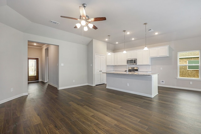 kitchen featuring visible vents, white cabinets, an island with sink, appliances with stainless steel finishes, and light stone counters