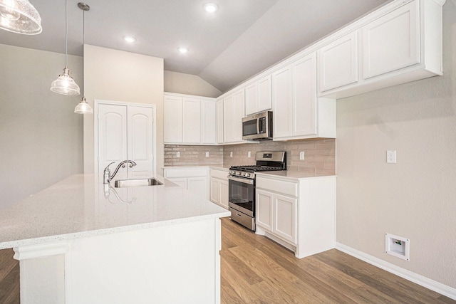2102 Twin Lakes Blvd, West Columbia, TX 77486 - kitchen featuring appliances with stainless steel finishes, light wood-style floors, decorative backsplash, white cabinetry, and lofted ceiling