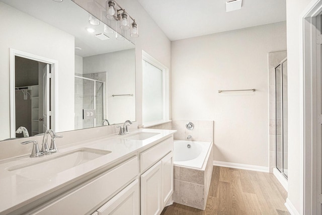 2102 Twin Lakes Blvd, West Columbia, TX 77486 - full bathroom featuring a stall shower, wood finished floors, a garden tub, and double vanity