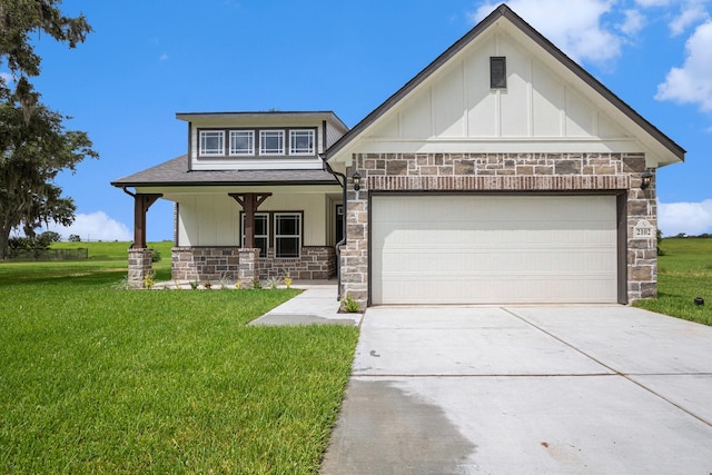 2102 Twin Lakes Blvd, West Columbia, TX 77486 - view of front of property with stone siding, covered porch, board and batten siding, concrete driveway, and a front yard