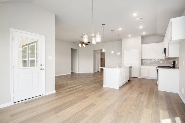 2102 Twin Lakes Blvd, West Columbia, TX 77486 - kitchen with appliances with stainless steel finishes, vaulted ceiling, tasteful backsplash, open floor plan, and light wood finished floors