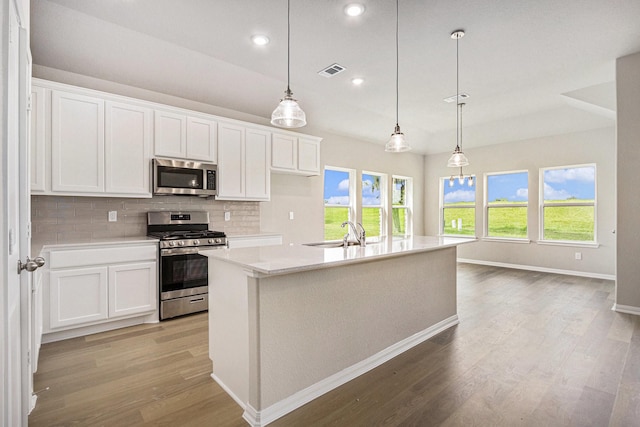 2102 Twin Lakes Blvd, West Columbia, TX 77486 - kitchen with stainless steel appliances, light wood-style floors, backsplash, light countertops, and white cabinets