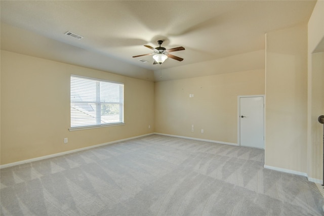 empty room featuring a ceiling fan, visible vents, light carpet, and baseboards