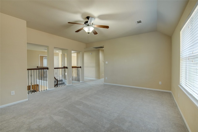 spare room with a ceiling fan, visible vents, vaulted ceiling, and baseboards