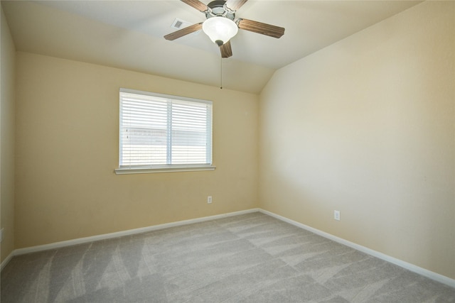 spare room featuring light carpet, ceiling fan, baseboards, and vaulted ceiling