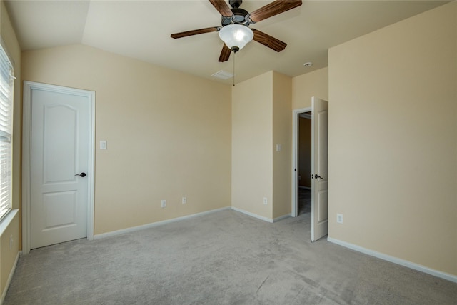 unfurnished room featuring light carpet, vaulted ceiling, a ceiling fan, and baseboards