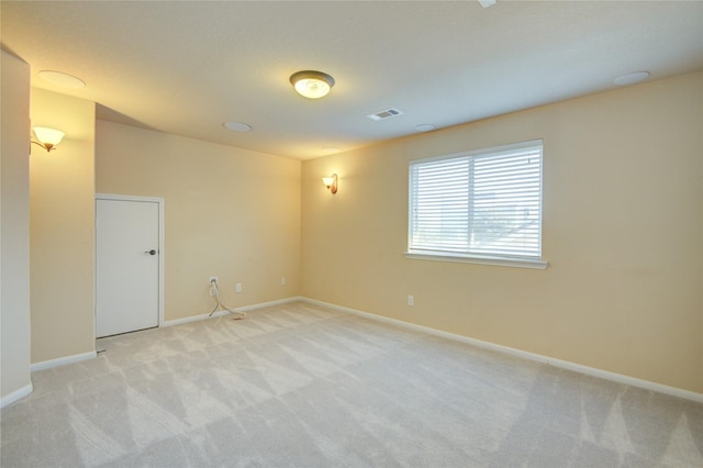 unfurnished room featuring baseboards, visible vents, and light colored carpet