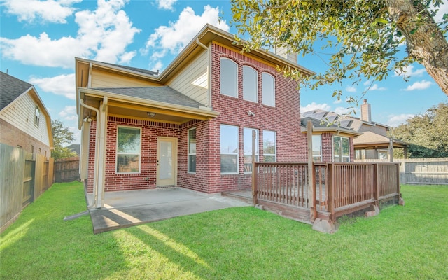 rear view of property with a yard, brick siding, and a patio area