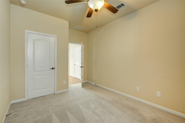 empty room featuring light carpet, baseboards, visible vents, and ceiling fan