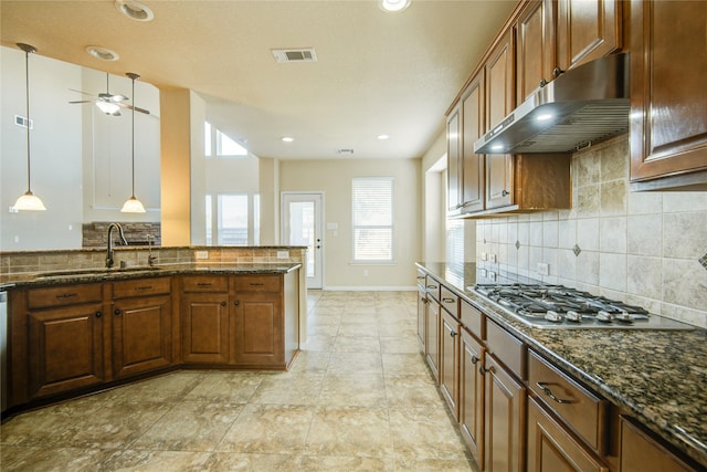 kitchen featuring under cabinet range hood, appliances with stainless steel finishes, visible vents, and brown cabinetry