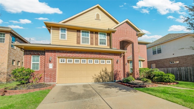 traditional-style home with brick siding, an attached garage, a front yard, fence, and driveway