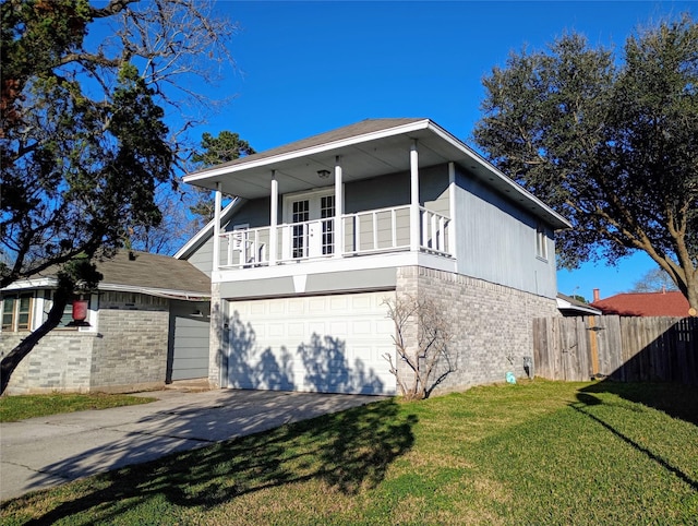 view of front of property with driveway, brick siding, a balcony, fence, and a front yard