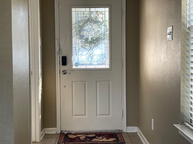 doorway featuring baseboards and tile patterned floors