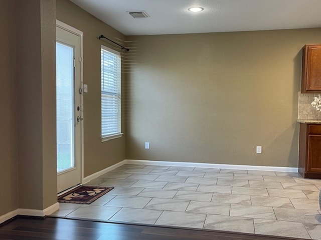 interior space with light wood-style floors, baseboards, and visible vents