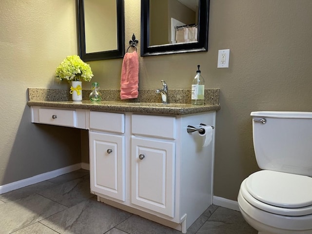 full bathroom featuring toilet, vanity, and baseboards