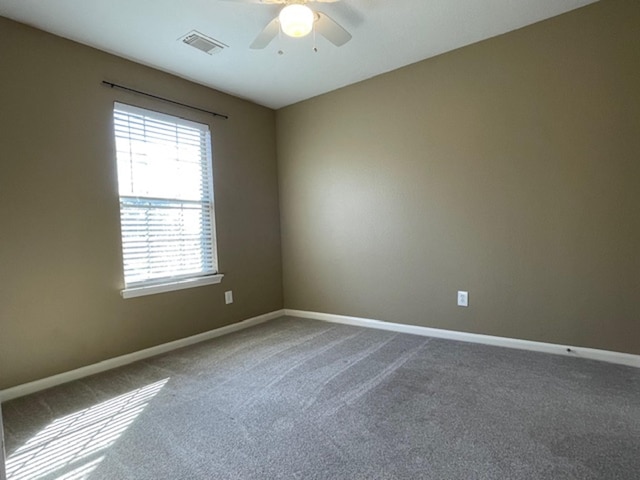 carpeted spare room featuring a ceiling fan, visible vents, and baseboards