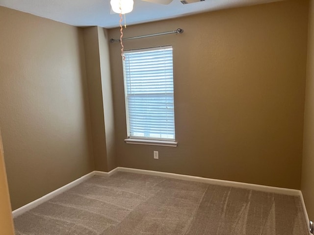 empty room with carpet floors, visible vents, and baseboards