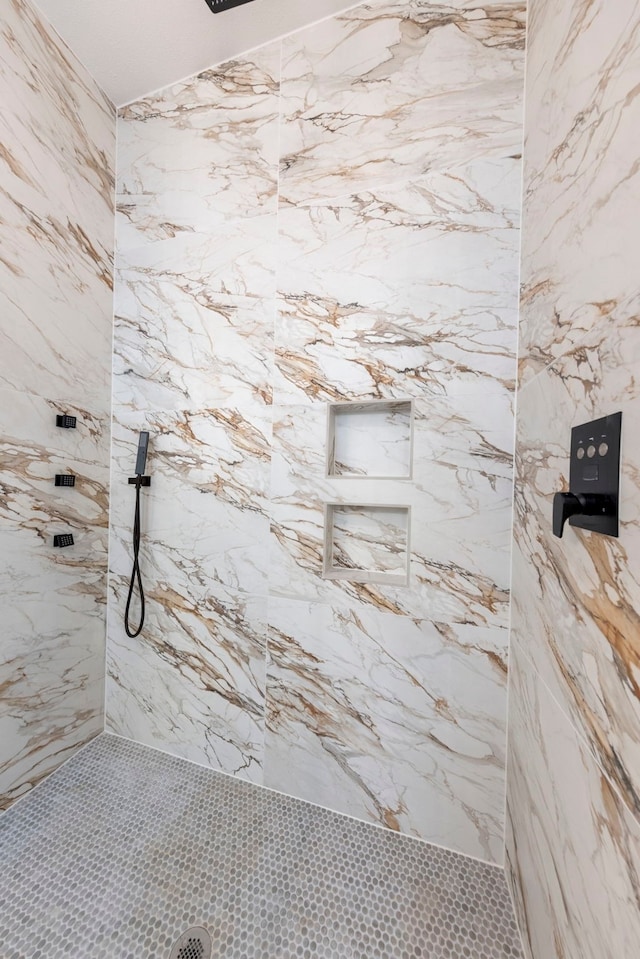 bathroom featuring a marble finish shower