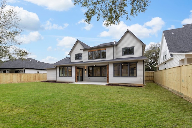 rear view of house with a patio area, a yard, and a fenced backyard