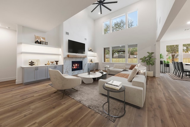 living area featuring dark wood-style floors, visible vents, a fireplace, and baseboards