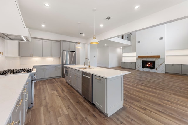 kitchen featuring stainless steel appliances, light countertops, custom exhaust hood, and gray cabinetry