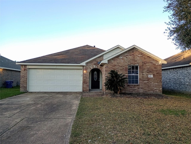 ranch-style house featuring a garage, concrete driveway, brick siding, and a front yard