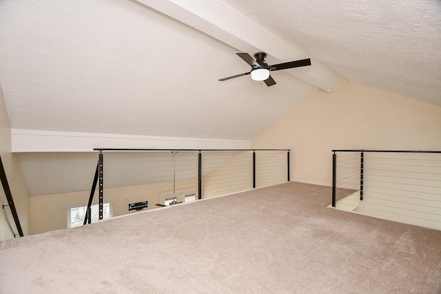 bonus room featuring lofted ceiling with beams, a textured ceiling, carpet, and a ceiling fan