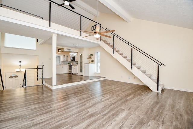 653 Davis Rd, League City, TX 77573 - unfurnished living room featuring high vaulted ceiling, beamed ceiling, a ceiling fan, and wood finished floors