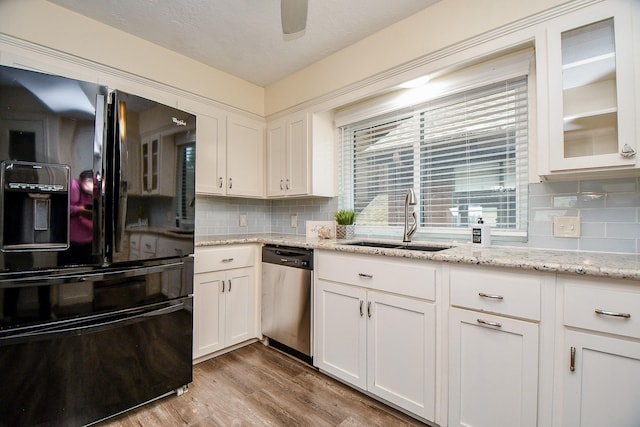 kitchen with black fridge with ice dispenser, stainless steel dishwasher, glass insert cabinets, white cabinetry, and a sink