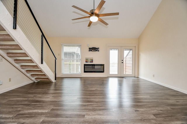 unfurnished living room featuring ceiling fan, dark wood-style flooring, baseboards, french doors, and stairway