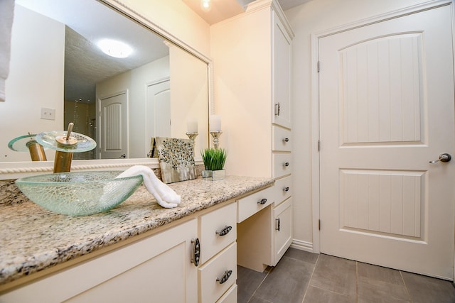 bathroom featuring tile patterned flooring and vanity