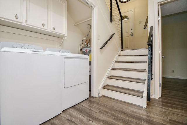 laundry room featuring cabinet space, baseboards, wood finished floors, and washing machine and clothes dryer