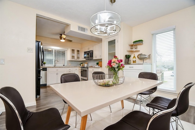 653 Davis Rd, League City, TX 77573 - dining room featuring light wood-type flooring, visible vents, baseboards, and ceiling fan with notable chandelier