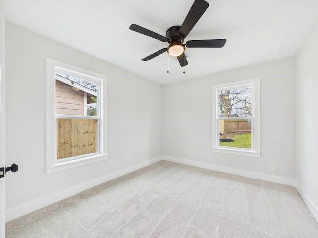 carpeted empty room with plenty of natural light, baseboards, and ceiling fan