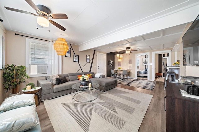 living area with ceiling fan, cooling unit, and wood finished floors