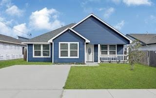 bungalow featuring covered porch and a front yard