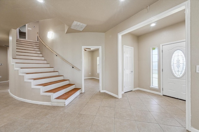 foyer entrance featuring light tile patterned floors, stairs, baseboards, and recessed lighting