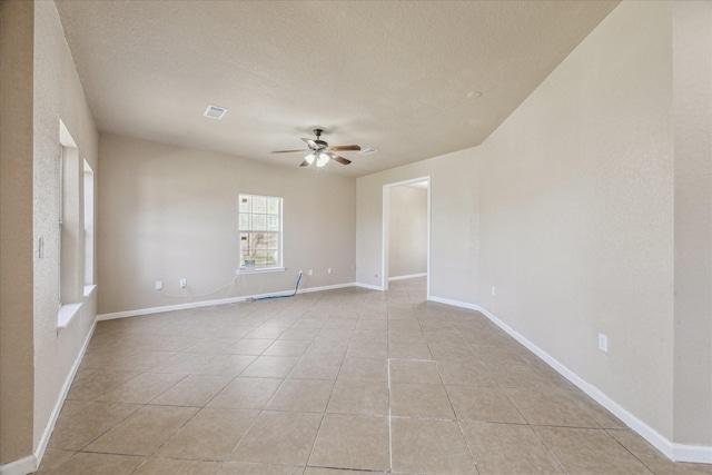 empty room with visible vents, baseboards, ceiling fan, a textured ceiling, and light tile patterned flooring