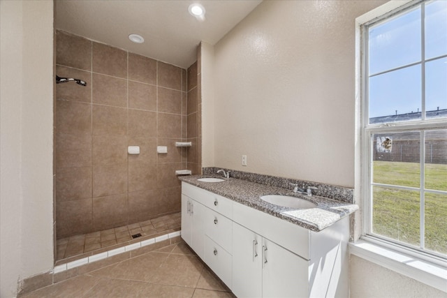 full bathroom with tile patterned flooring, a sink, a tile shower, and recessed lighting