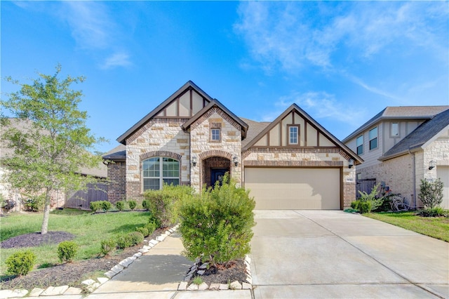 tudor house with a garage, concrete driveway, stucco siding, a front lawn, and brick siding